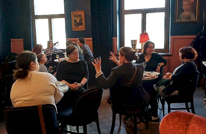 Ihmiset keskustelevat ravintolassa. Kuvaaja Minna Holopainen.