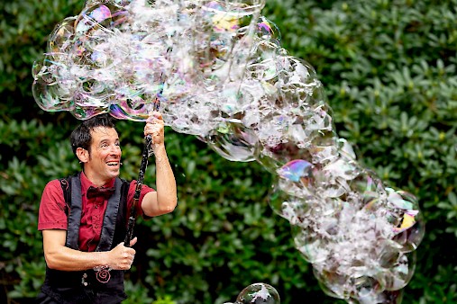 Man creates a cluster of soap bubbles