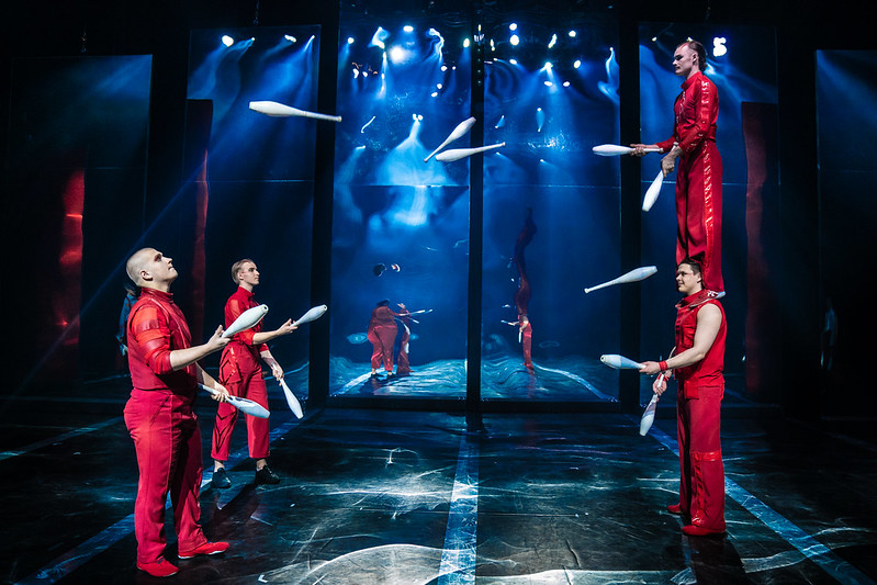 4 circus performers throw bowling pins to each other