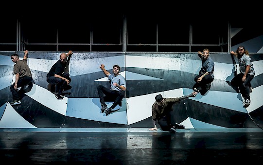 Dancers are sliding down a ramp.