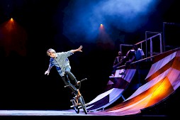A biker doing a trick on a skate ramp.